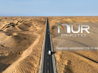 Vehicles drive on a desert highway in Bazhou, Xinjiang province, China, on September 23, 2024. (