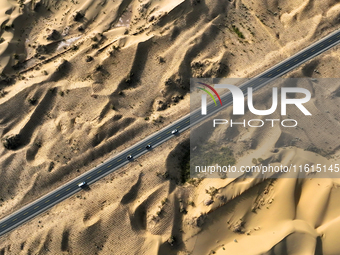 Vehicles drive on a desert highway in Bazhou, Xinjiang province, China, on September 23, 2024. (