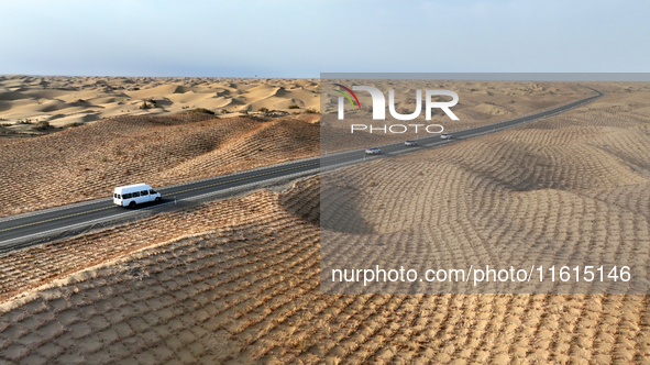 Vehicles drive on a desert highway in Bazhou, Xinjiang province, China, on September 23, 2024. 