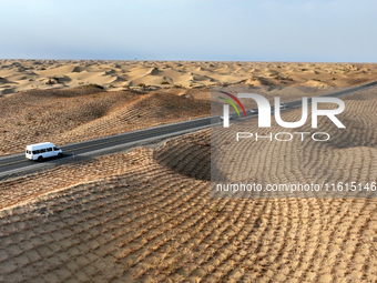 Vehicles drive on a desert highway in Bazhou, Xinjiang province, China, on September 23, 2024. (