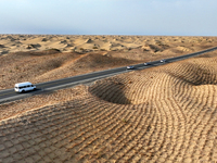 Vehicles drive on a desert highway in Bazhou, Xinjiang province, China, on September 23, 2024. (