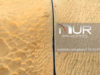 Vehicles drive on a desert highway in Bazhou, Xinjiang province, China, on September 23, 2024. (