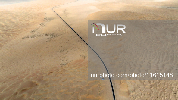 Vehicles drive on a desert highway in Bazhou, Xinjiang province, China, on September 23, 2024. 