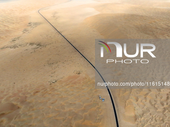 Vehicles drive on a desert highway in Bazhou, Xinjiang province, China, on September 23, 2024. (