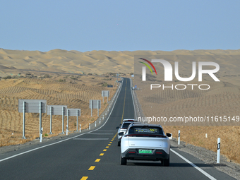 Vehicles drive on a desert highway in Bazhou, Xinjiang province, China, on September 23, 2024. (