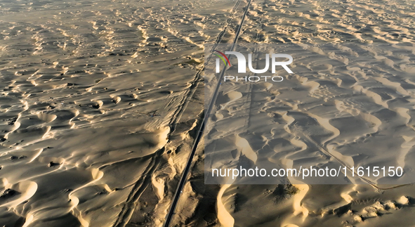 Vehicles drive on a desert highway in Bazhou, Xinjiang province, China, on September 23, 2024. 