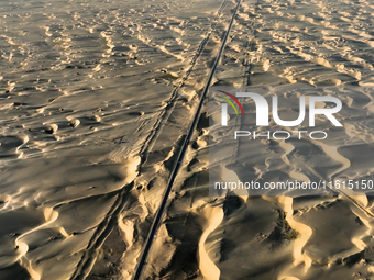 Vehicles drive on a desert highway in Bazhou, Xinjiang province, China, on September 23, 2024. (