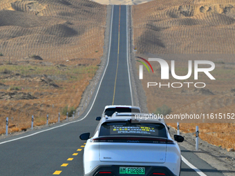 Vehicles drive on a desert highway in Bazhou, Xinjiang province, China, on September 23, 2024. (