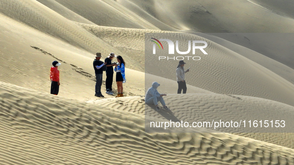 Tourists visit the ''Langsha Mountain'' scenic spot section of the desert highway in Bazhou, Xinjiang, China, on September 23, 2024. 