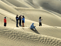 Tourists visit the ''Langsha Mountain'' scenic spot section of the desert highway in Bazhou, Xinjiang, China, on September 23, 2024. (