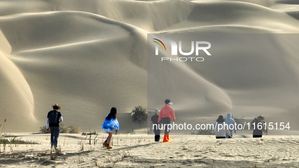 Tourists visit the ''Langsha Mountain'' scenic spot section of the desert highway in Bazhou, Xinjiang, China, on September 23, 2024. 