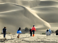 Tourists visit the ''Langsha Mountain'' scenic spot section of the desert highway in Bazhou, Xinjiang, China, on September 23, 2024. (