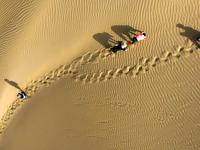 Tourists visit the ''Langsha Mountain'' scenic spot section of the desert highway in Bazhou, Xinjiang, China, on September 23, 2024. (