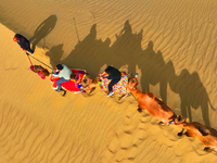 Tourists ride camels to view the scenery of nature in Bazhou, Xinjiang, China, on September 23, 2024. (