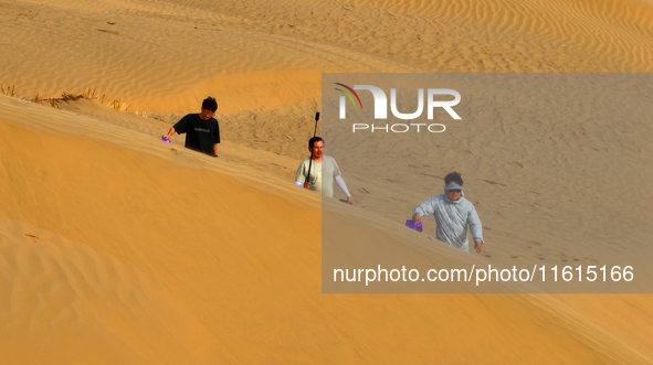 Tourists play on the desert road in Bazhou, Xinjiang, China, on September 23, 2024. 