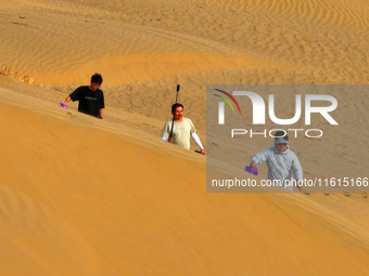 Tourists play on the desert road in Bazhou, Xinjiang, China, on September 23, 2024. (