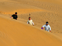 Tourists play on the desert road in Bazhou, Xinjiang, China, on September 23, 2024. (