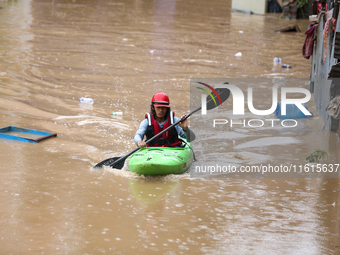 A Nepal Army personnel wades through a flooded area in search of stranded and trapped people using a kayak in Kathmandu, Nepal, on September...