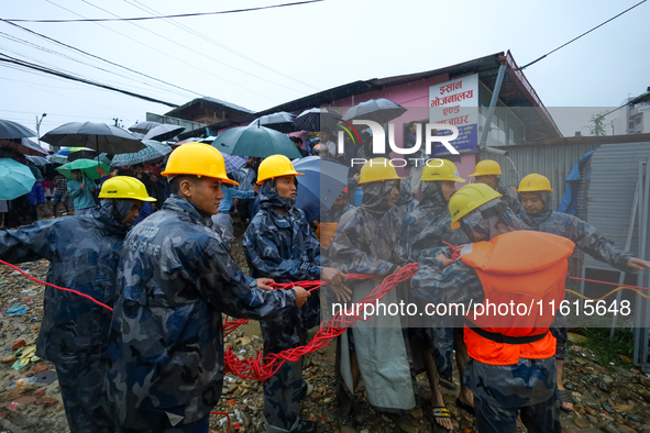 Nepal's Armed Police Force personnel prepare for a rescue operation to bring out a stranded person from a flooded river in Lalitpur, Nepal,...