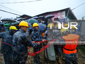 Nepal's Armed Police Force personnel prepare for a rescue operation to bring out a stranded person from a flooded river in Lalitpur, Nepal,...