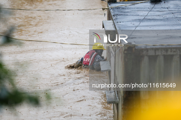 A Nepal Army personnel wades through a flooded area to rescue a stranded person in Lalitpur, Nepal, on September 28, 2024. At least 32 peopl...