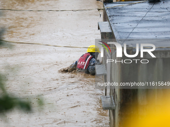 A Nepal Army personnel wades through a flooded area to rescue a stranded person in Lalitpur, Nepal, on September 28, 2024. At least 32 peopl...