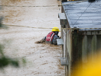 A Nepal Army personnel wades through a flooded area to rescue a stranded person in Lalitpur, Nepal, on September 28, 2024. At least 32 peopl...