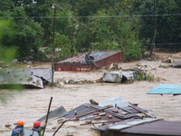 Nepal's Armed Police Force personnel attempt to reach a stranded person from a flooded river in Lalitpur, Nepal, on September 28, 2024. At l...