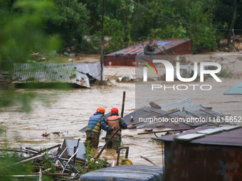 Nepal's Armed Police Force personnel attempt to reach a stranded person from a flooded river in Lalitpur, Nepal, on September 28, 2024. At l...