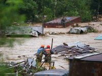 Nepal's Armed Police Force personnel attempt to reach a stranded person from a flooded river in Lalitpur, Nepal, on September 28, 2024. At l...