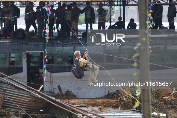 Nepal's Armed Police Force rescues a stranded person using a zipline rescue method from a flooded river in Lalitpur, Nepal, on September 28,...