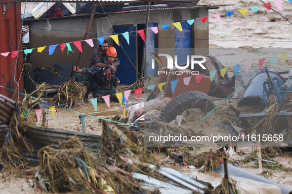 Nepal's Armed Police Force personnel rescue a stranded person from a flooded river in Lalitpur, Nepal, on September 28, 2024. At least 32 pe...