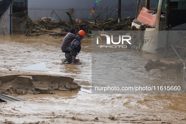 Nepal's Armed Police Force personnel rescue a stranded person from a flooded river in Lalitpur, Nepal, on September 28, 2024. At least 32 pe...