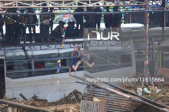 Nepal's Armed Police Force rescues stranded people using a zipline rescue method from a flooded river in Lalitpur, Nepal, on September 28, 2...