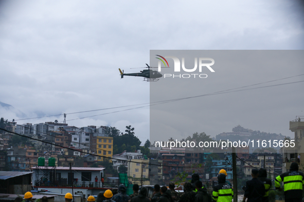 A Nepal Army helicopter conducts a long-line rescue to retrieve stranded people from a flooded river in Lalitpur, Nepal, on September 28, 20...