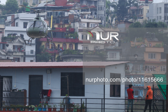 A Nepal Army helicopter conducts a long-line rescue to retrieve stranded people from a flooded river in Lalitpur, Nepal, on September 28, 20...