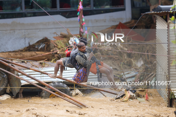 Nepal's Armed Police Force rescues stranded people using a zipline rescue method from a flooded river in Lalitpur, Nepal, on September 28, 2...