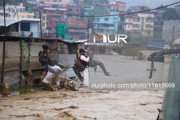 Nepal's Armed Police Force rescues stranded people using a zipline rescue method from a flooded river in Lalitpur, Nepal, on September 28, 2...