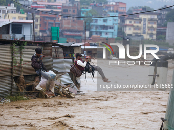 Nepal's Armed Police Force rescues stranded people using a zipline rescue method from a flooded river in Lalitpur, Nepal, on September 28, 2...