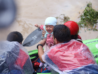 A Nepal Army personnel evacuates an infant using a kayak from a flooded residential area in Kathmandu, Nepal, on September 28, 2024. At leas...