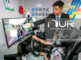 Students learn driving skills on an AI simulator at Landun Smart Driving School in Hua County, Anyang, China, on September 28, 2024. (