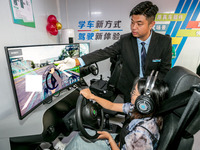 Students learn driving skills on an AI simulator at Landun Smart Driving School in Hua County, Anyang, China, on September 28, 2024. (