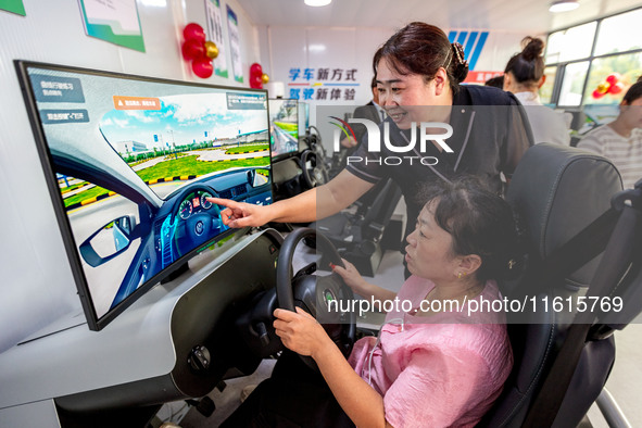 Students learn driving skills on an AI simulator at Landun Smart Driving School in Hua County, Anyang, China, on September 28, 2024. 