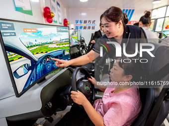 Students learn driving skills on an AI simulator at Landun Smart Driving School in Hua County, Anyang, China, on September 28, 2024. (