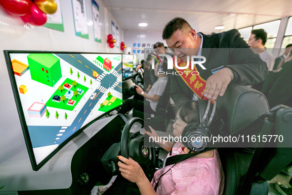 Students learn driving skills on an AI simulator at Landun Smart Driving School in Hua County, Anyang, China, on September 28, 2024. 