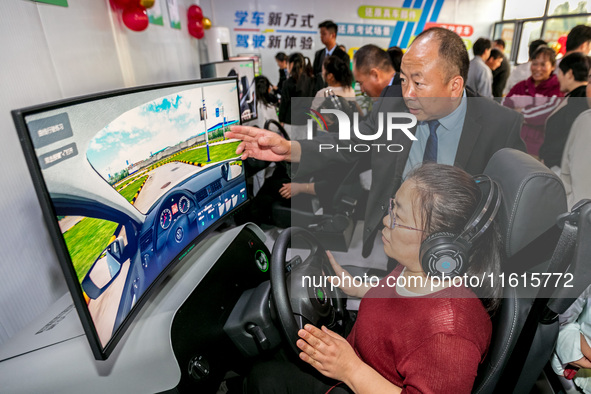 Students learn driving skills on an AI simulator at Landun Smart Driving School in Hua County, Anyang, China, on September 28, 2024. 