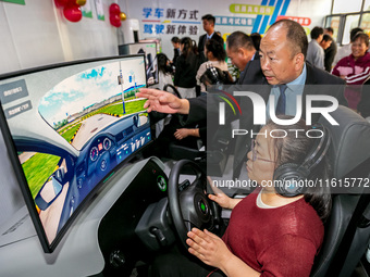 Students learn driving skills on an AI simulator at Landun Smart Driving School in Hua County, Anyang, China, on September 28, 2024. (