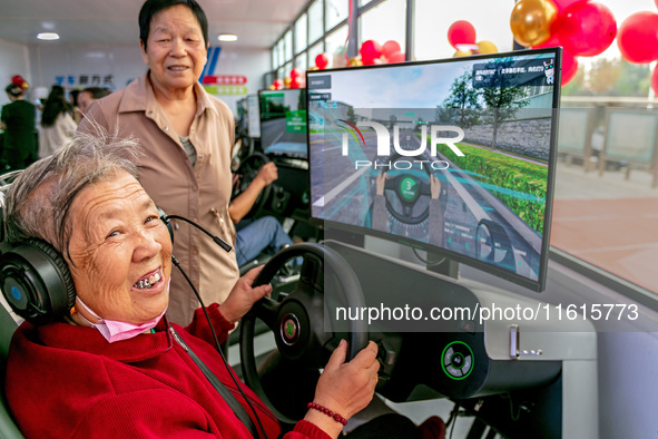 A 93-year-old grandmother learns driving skills on an AI intelligent simulator at the Blue Shield Intelligent Driving School in Huaxian Coun...