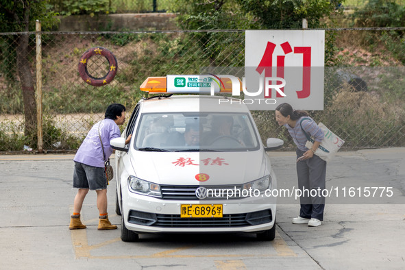 Students learn about the advantages of AI intelligent coaching cars at Blue Shield Intelligent Driving School in Huaxian County, Anyang, Chi...