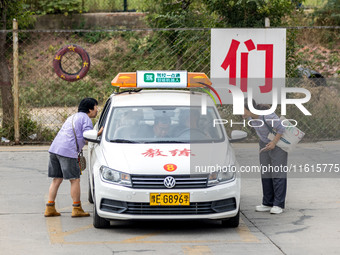 Students learn about the advantages of AI intelligent coaching cars at Blue Shield Intelligent Driving School in Huaxian County, Anyang, Chi...